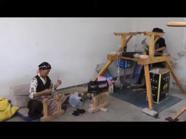 Artigiani tibetani al lavoro su telai tradizionali per la tessitura di tappeti tibetani fatti a mano