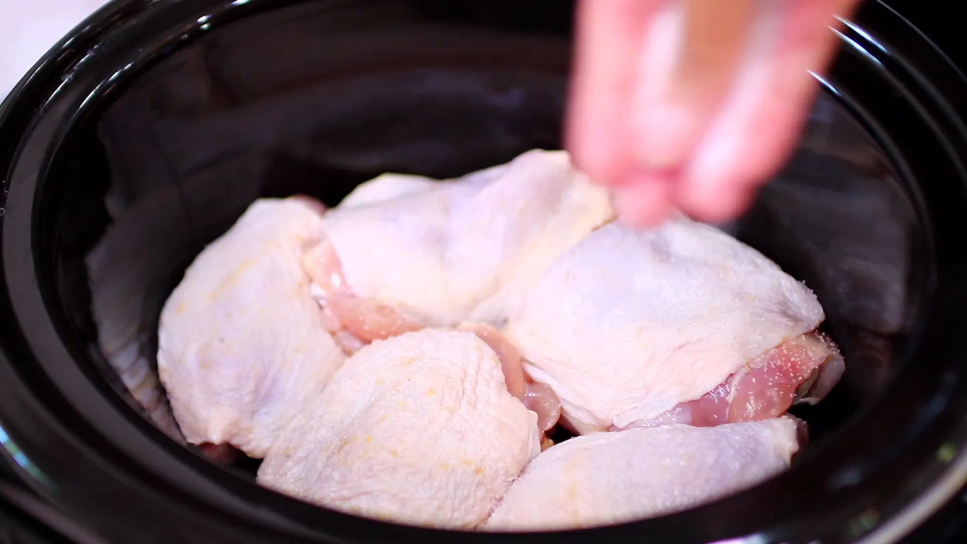 Seasoning chicken thighs with salt and pepper