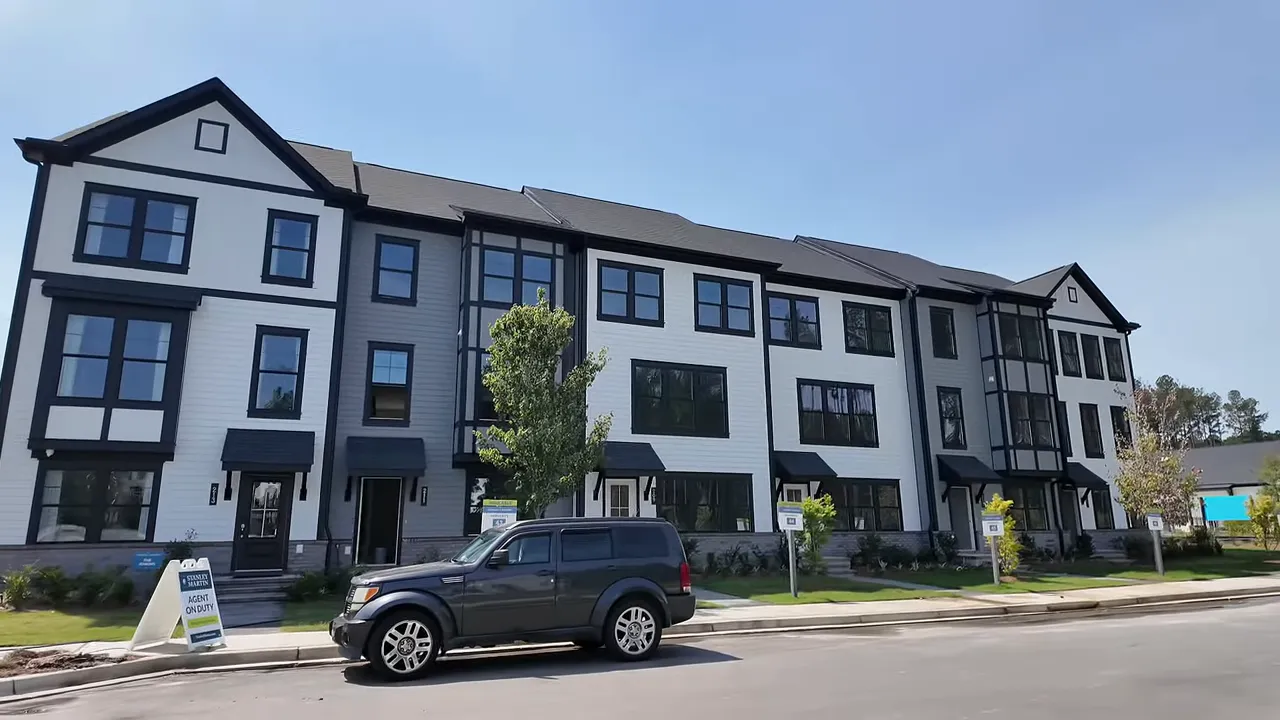 Front exterior of three story townhomes with black windows and modern trim