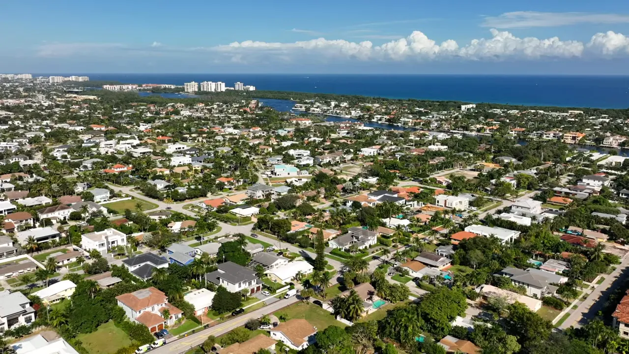 Title slide reading 'TOP 8 REASONS WHY HOME PRICES' overlaid on a Florida park scene with the presenter faintly visible behind the text