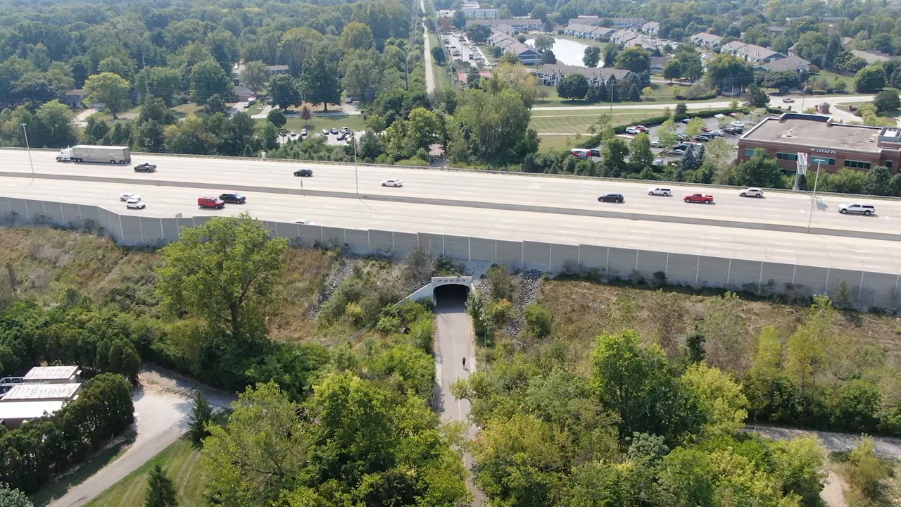 Map of Indianapolis with I‑465 highlighted and red dashed radial corridors showing major travel arteries
