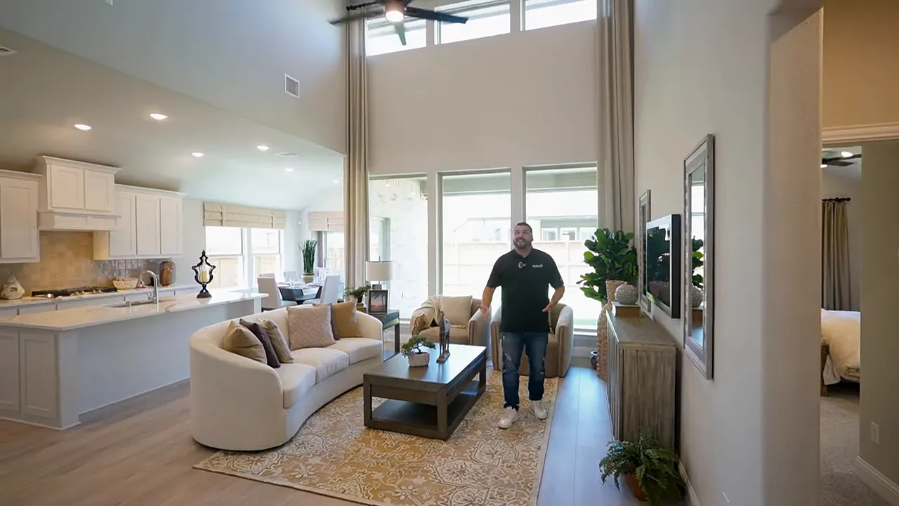 Soaring two‑story living room with transom windows and three large back windows