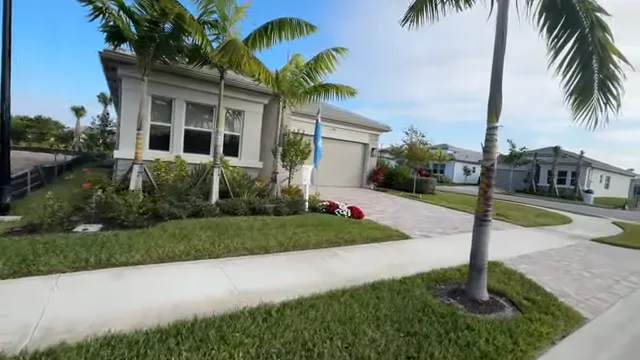White building beside landscaped parking area and palm trees