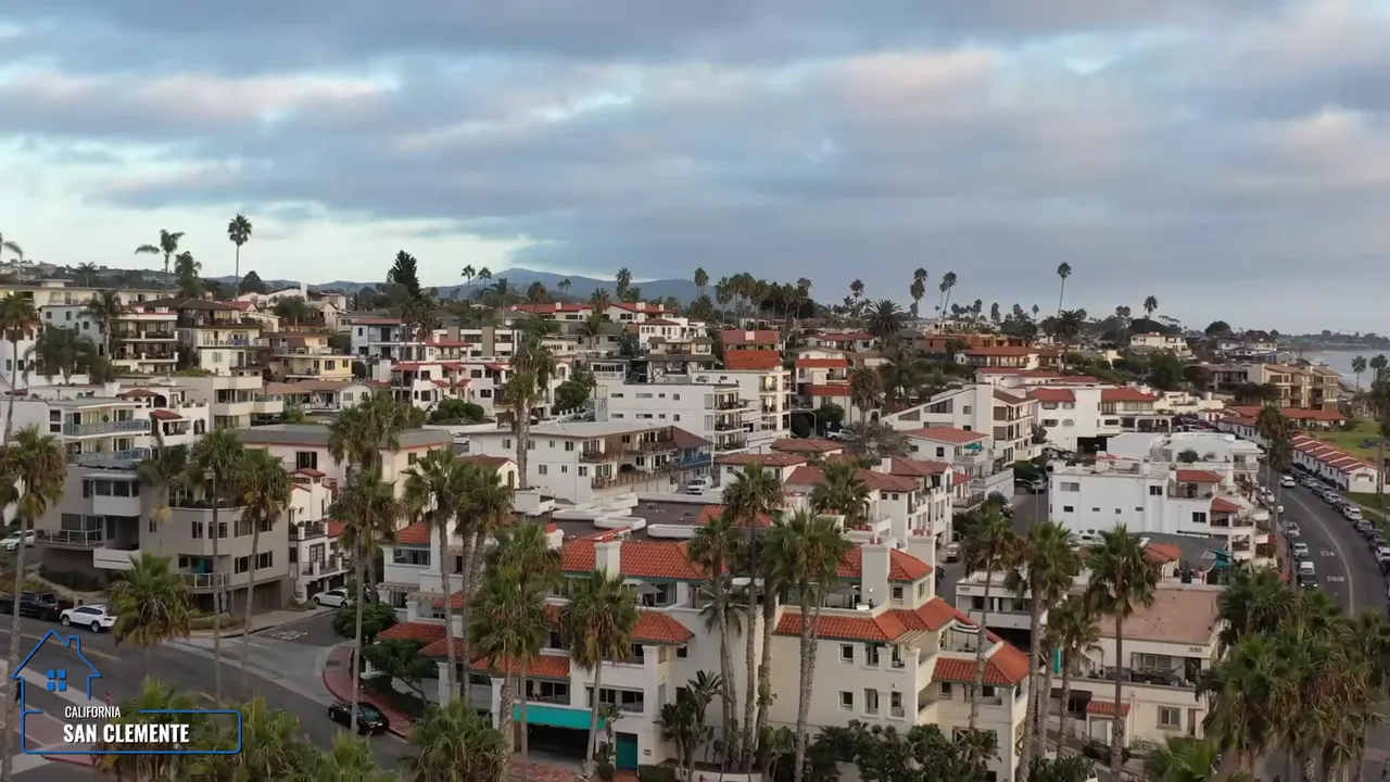 Spanish style downtown buildings with red tile roofs and parked cars along a street in San Clemente