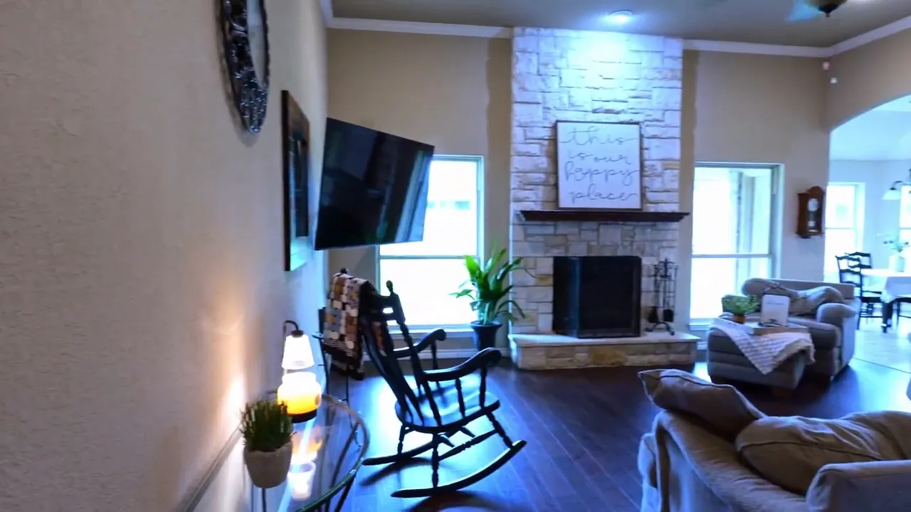 living room with stone fireplace seating and wall mounted television