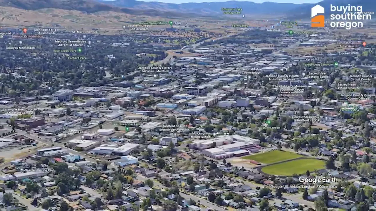 Clear Google Earth aerial view down a main street toward downtown Medford with surrounding neighborhoods