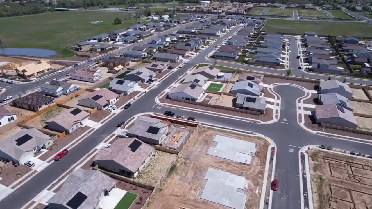 Two hosts facing the camera with a laptop, discussing Vernon Street and downtown plans for Roseville