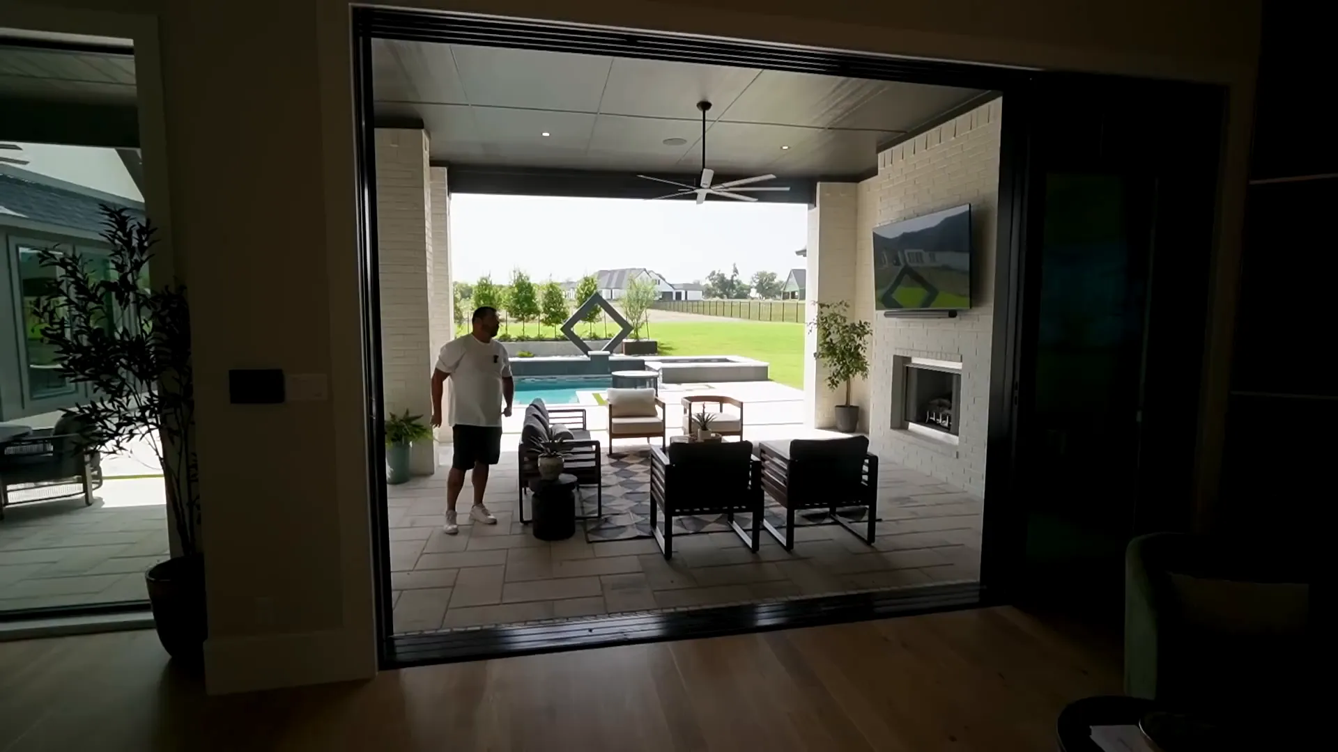 Triple sliding glass doors fully open to outdoor living and pool