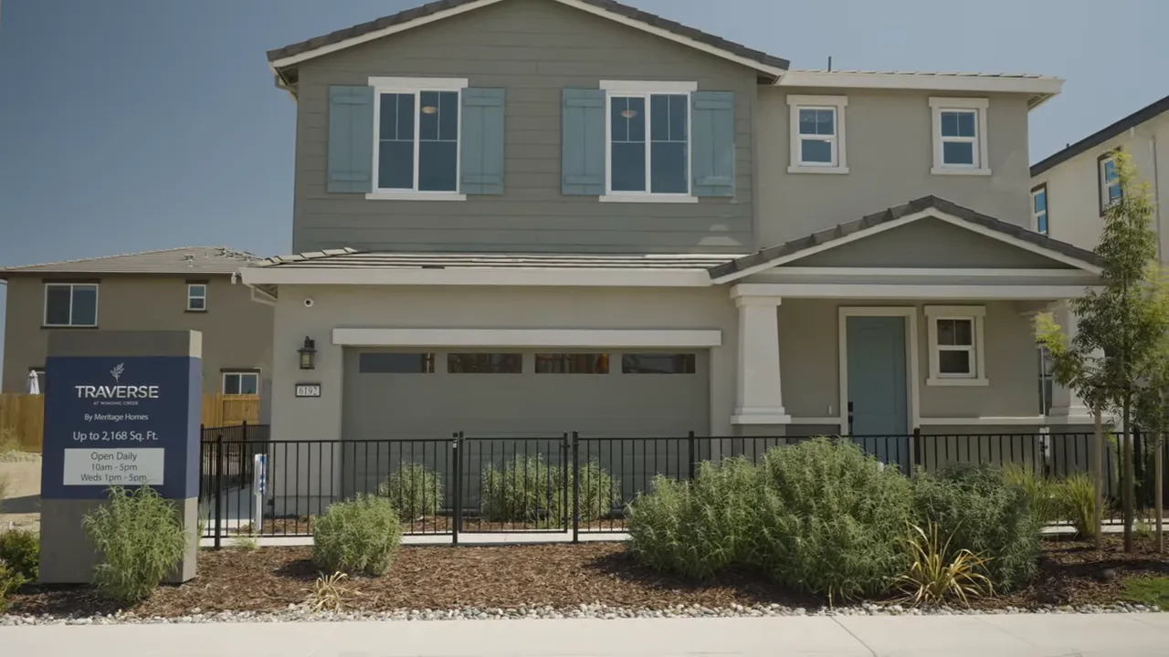 Couple entering a model home through the front door, bright interior visible