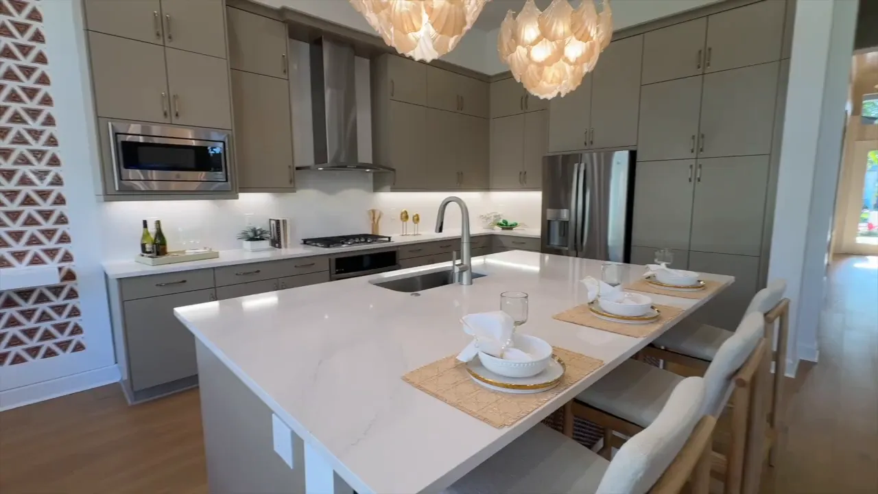 Wide view of bright rear dining area opening to the kitchen in the Stellar model at Valencia Sky Naples FL