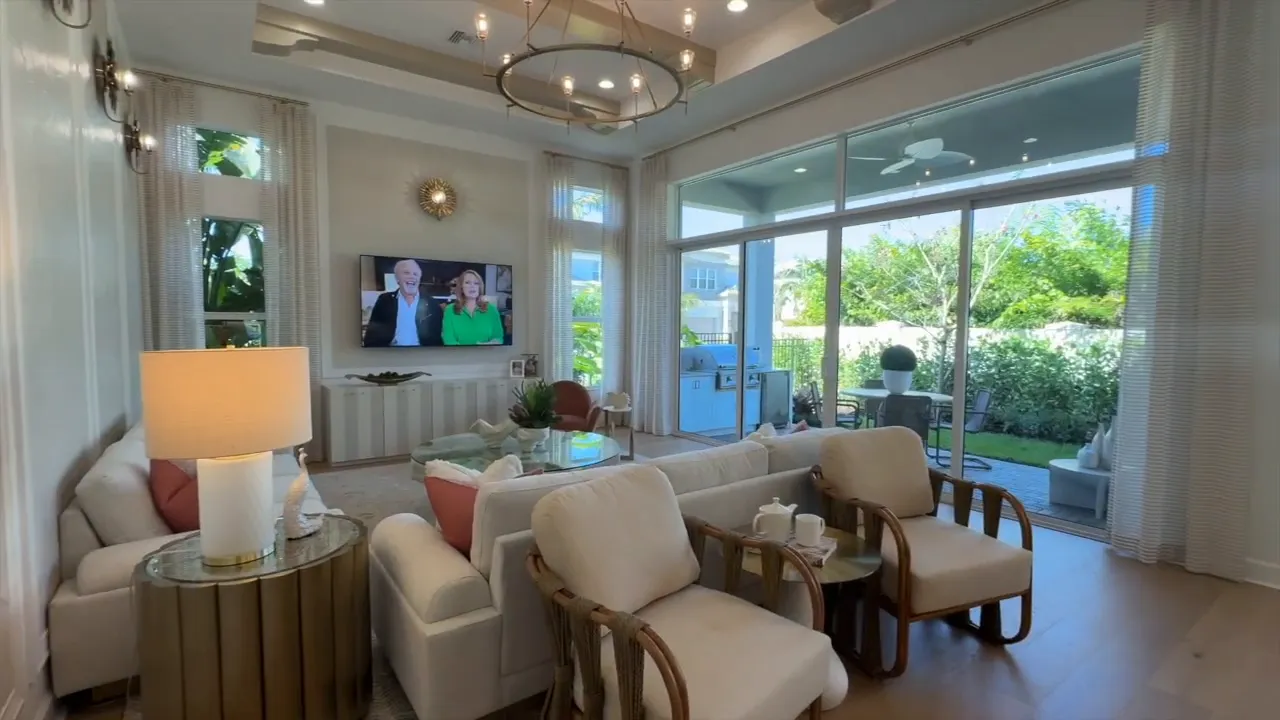 Living room with large sliding glass doors and backyard view in the Stellar model at Valencia Sky Naples FL