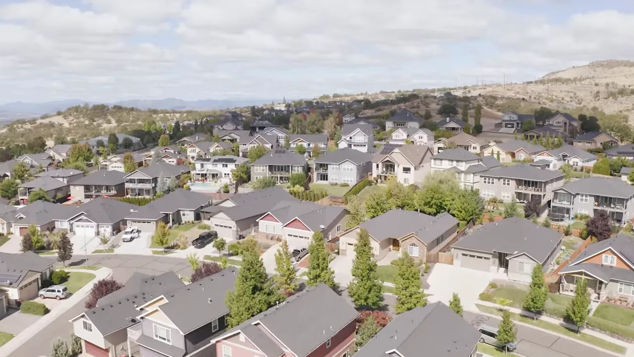 Presenter seated on a couch in a bright office discussing moving to Southern Oregon.