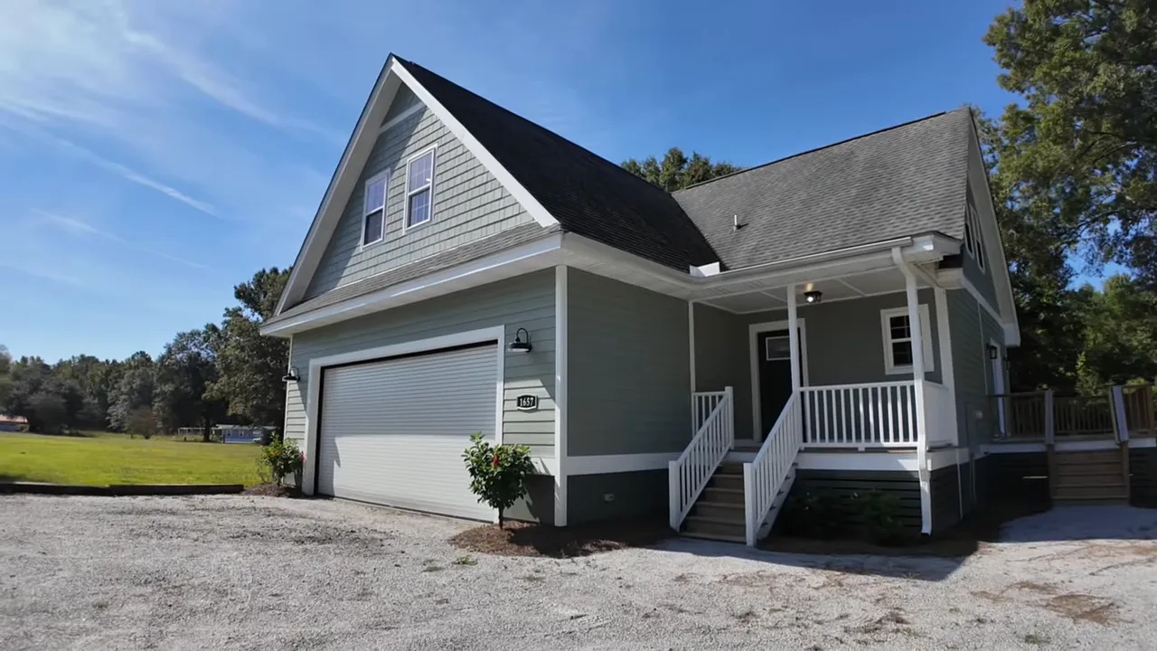 Presenter pointing at an oversized roll-up garage door and opener, highlighting ceiling height and wide bay space.
