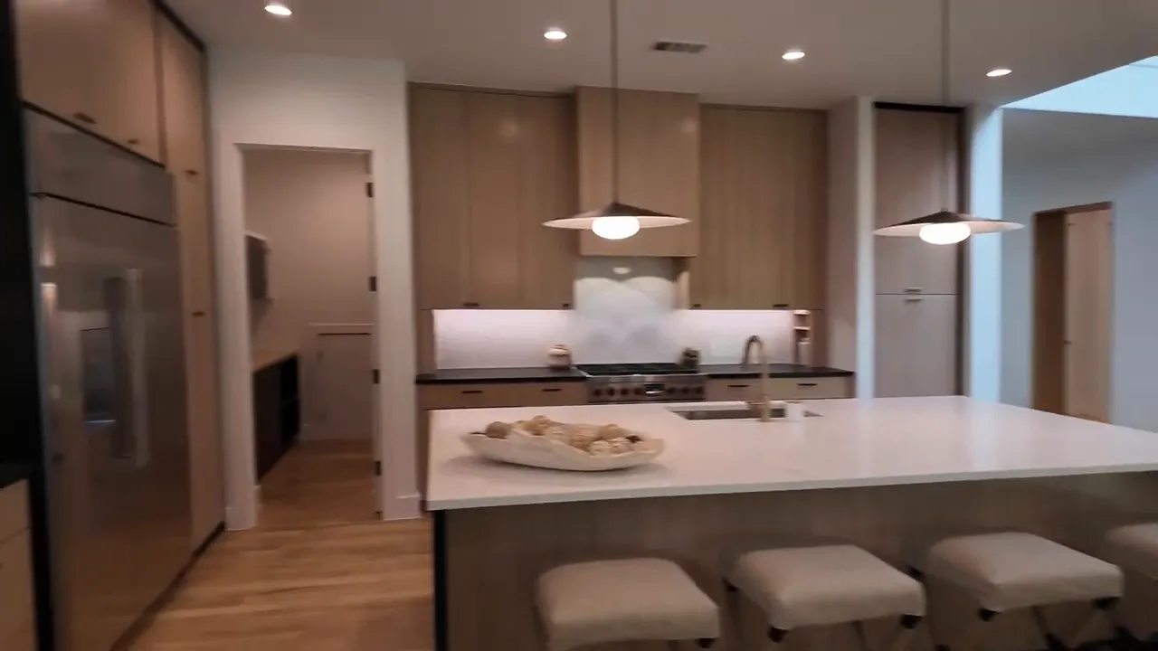 Luxury kitchen with gas range, custom cabinetry, and marble-look countertops