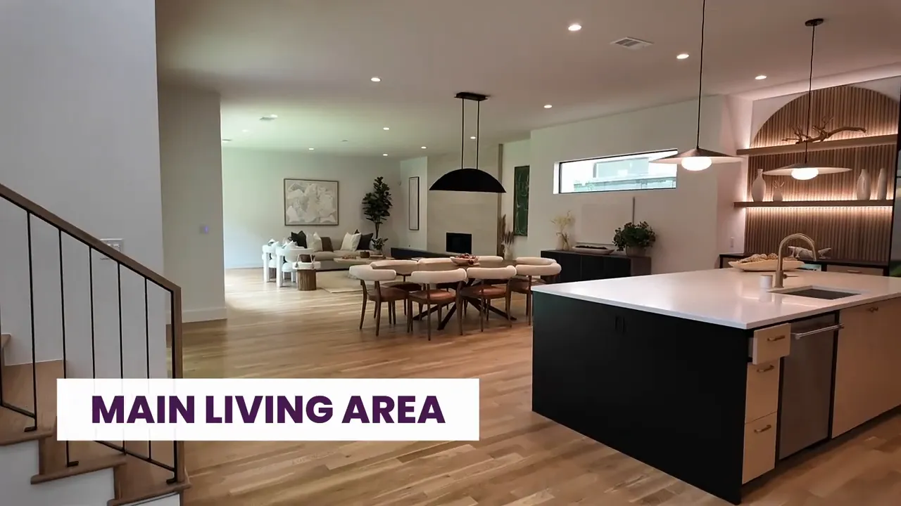 Open-concept kitchen and dining area with modern island, pendant lights, and built-in fireplace wall