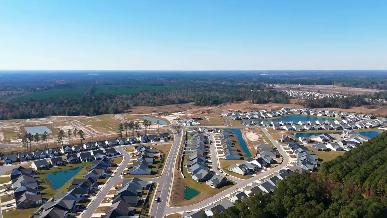 Presenter standing in a home's entryway speaking to camera about the home's benefits