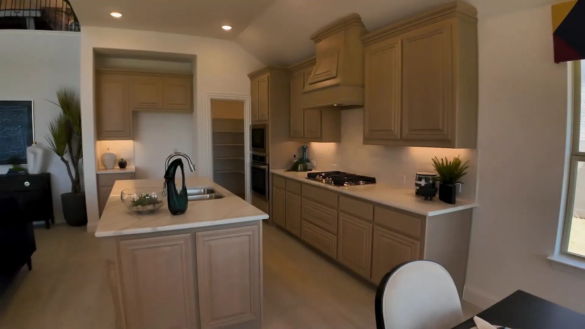 Modern kitchen with light cabinets and thick-veined countertops