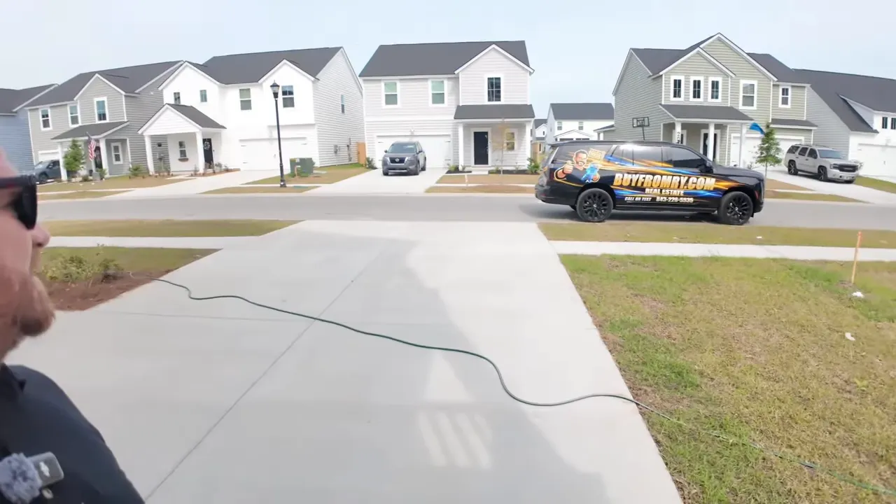 Covered driveway and garage area exterior of a new construction home with white railings in Summers Corner SC