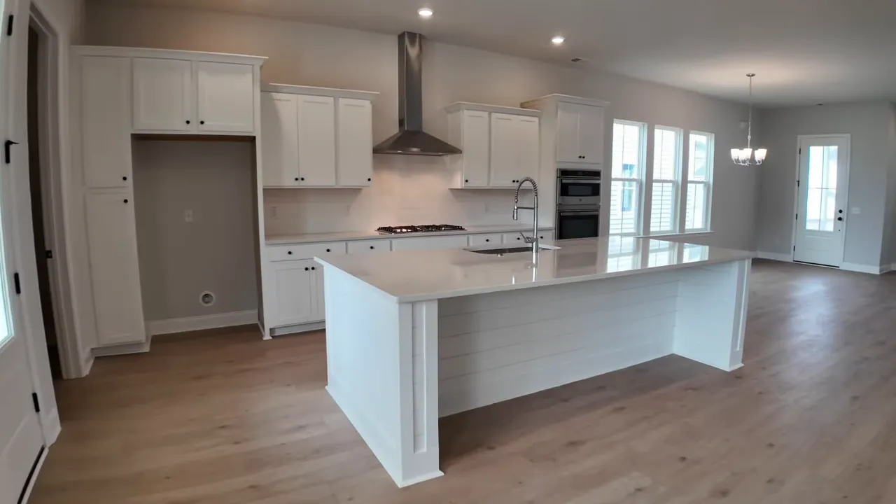 Bright new construction kitchen with white cabinetry, quartz island, and stainless appliances