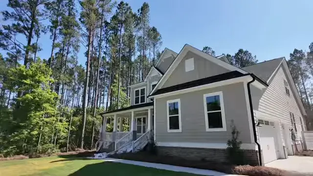 Elevated two story home with three car garage and wooded lot