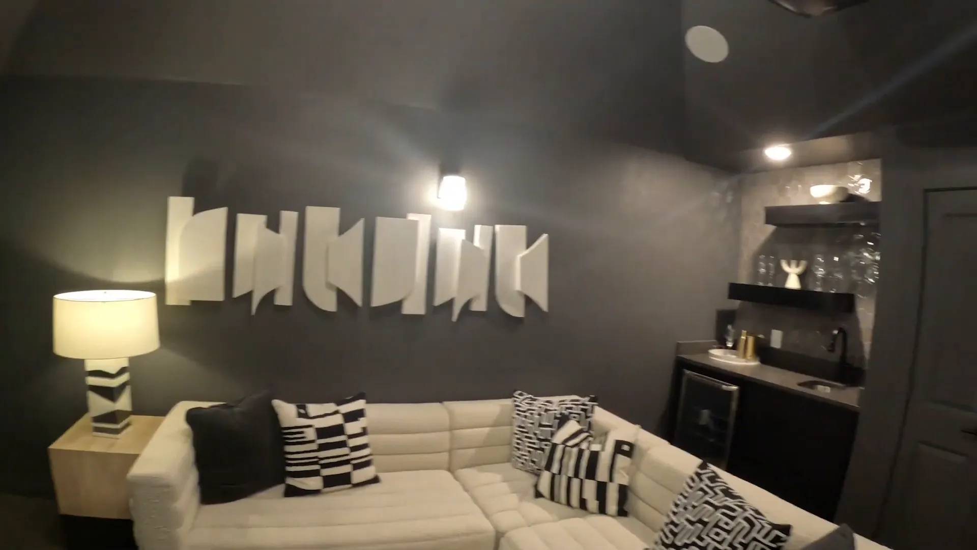 Dark media room with projection screen sectional sofa and built-in shelves