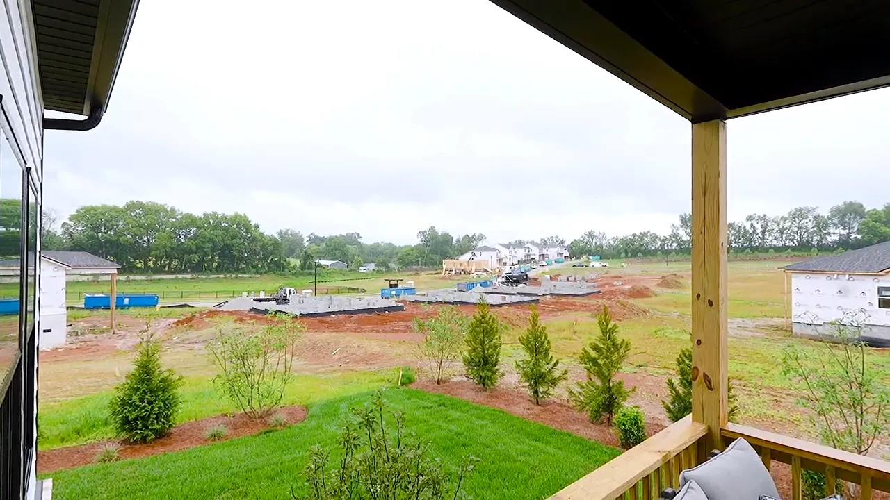 Covered rear deck with seating overlooking developing neighborhood