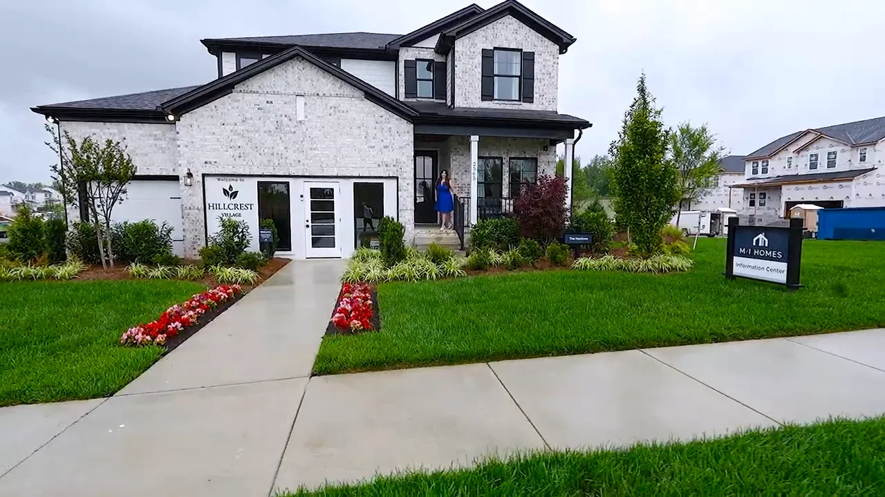 Brick two-story model home with covered porch and three-car garage
