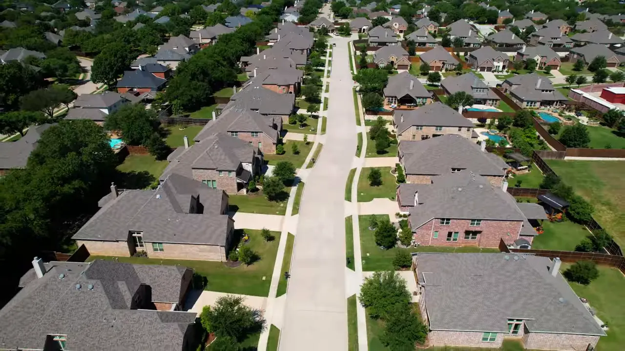 Presenter pointing at a large monitor displaying a DFW map of new-construction listings and price clusters