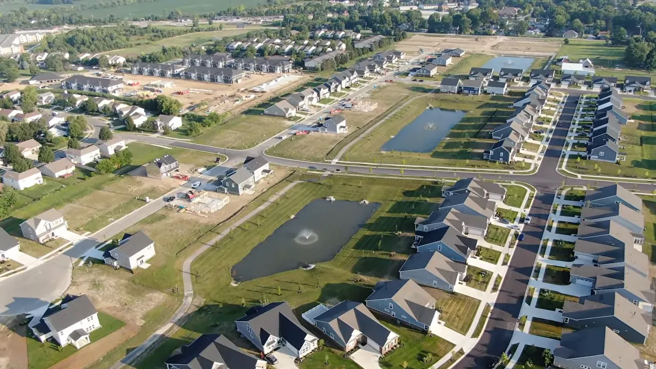 Aerial view of a large suburban neighborhood with ponds and rows of newer homes in McCordsville