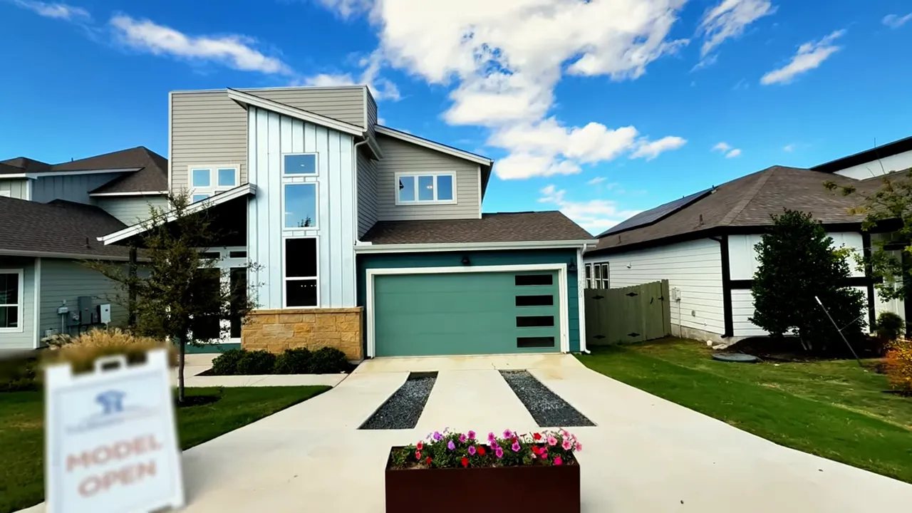 Stainless-steel refrigerator, built-in microwave and oven with light wood cabinets and countertop in Thurman Homes kitchen