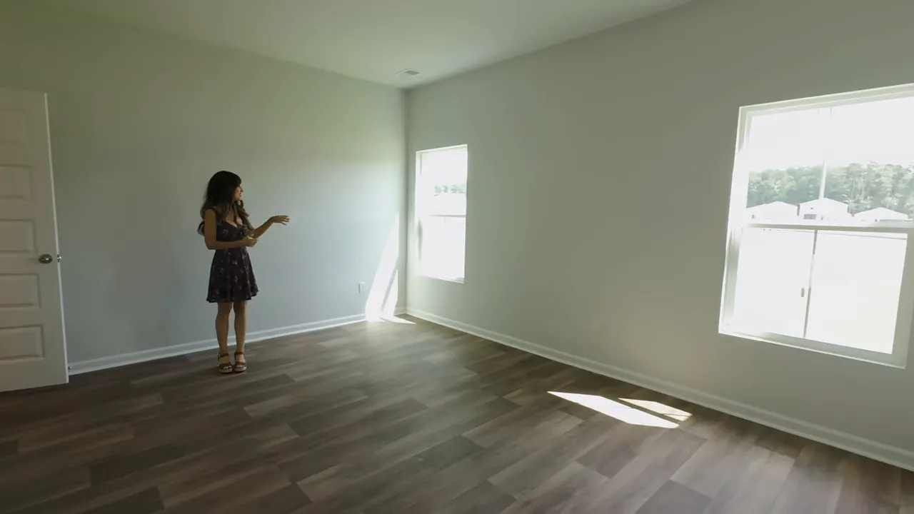 New construction empty room with window natural light and dark wood luxury vinyl plank flooring