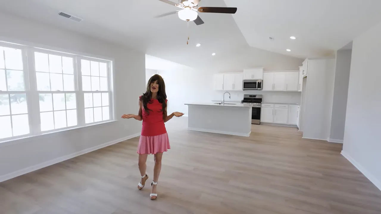 Open main living room with large windows and hardwood-style floors in a Conway SC new construction home