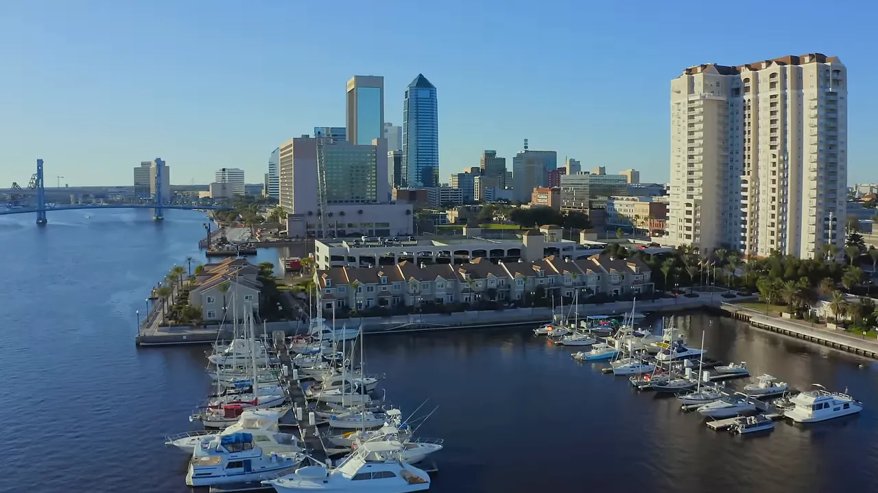 Wide shot of presenter in home office with bookshelf and branded monitor