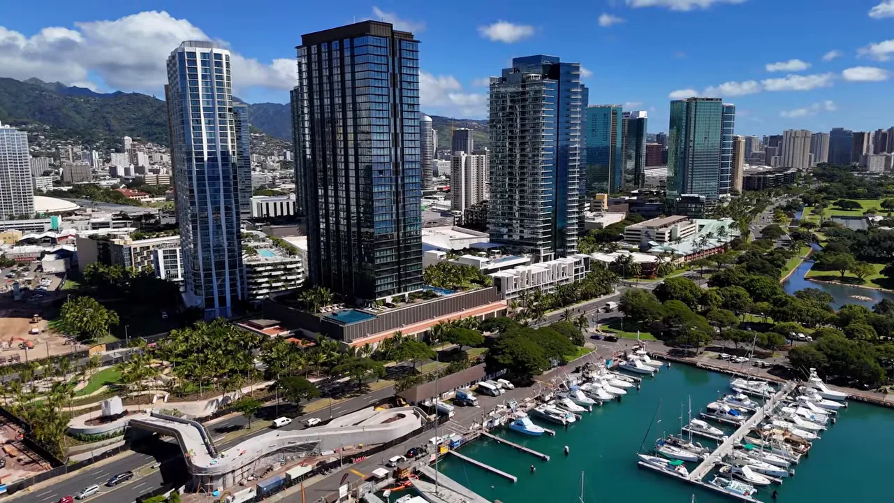 Aerial view of Honolulu skyline with mountains and high-rise buildings under blue skies