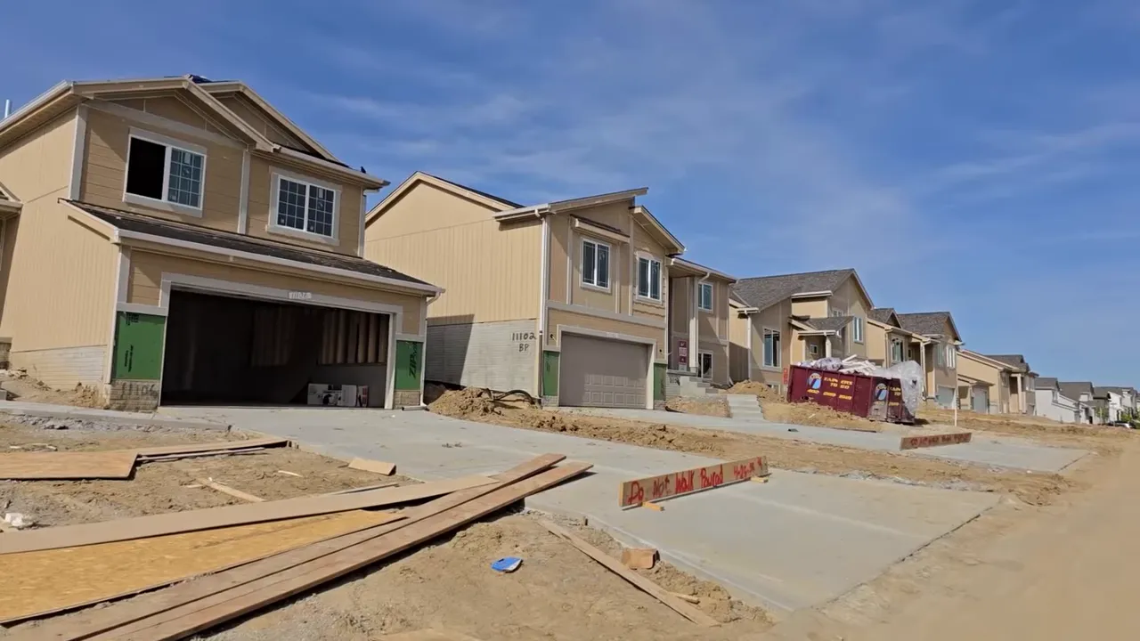 Homes under construction with a telehandler and building materials on site
