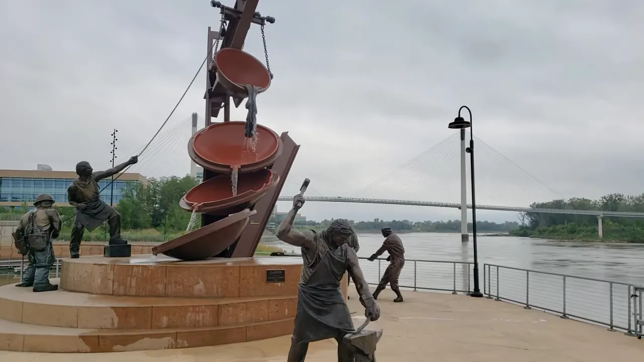 Aerial view of riverfront industrial smelting site with highway overpasses and adjacent river