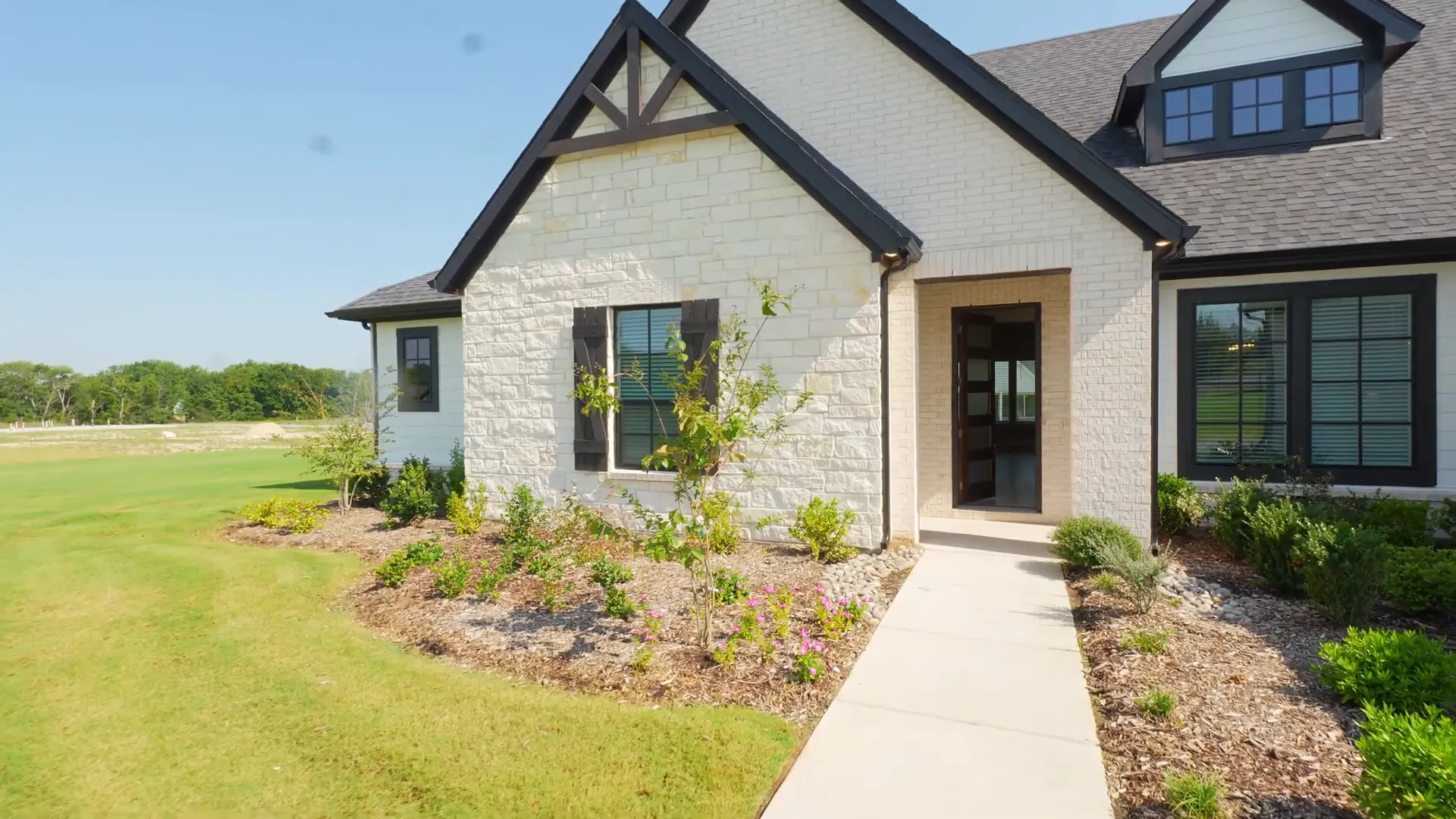 Front exterior of the inventory home with large porch and stonework