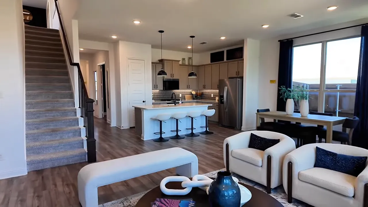 Open living room with kitchen island dining space and staircase