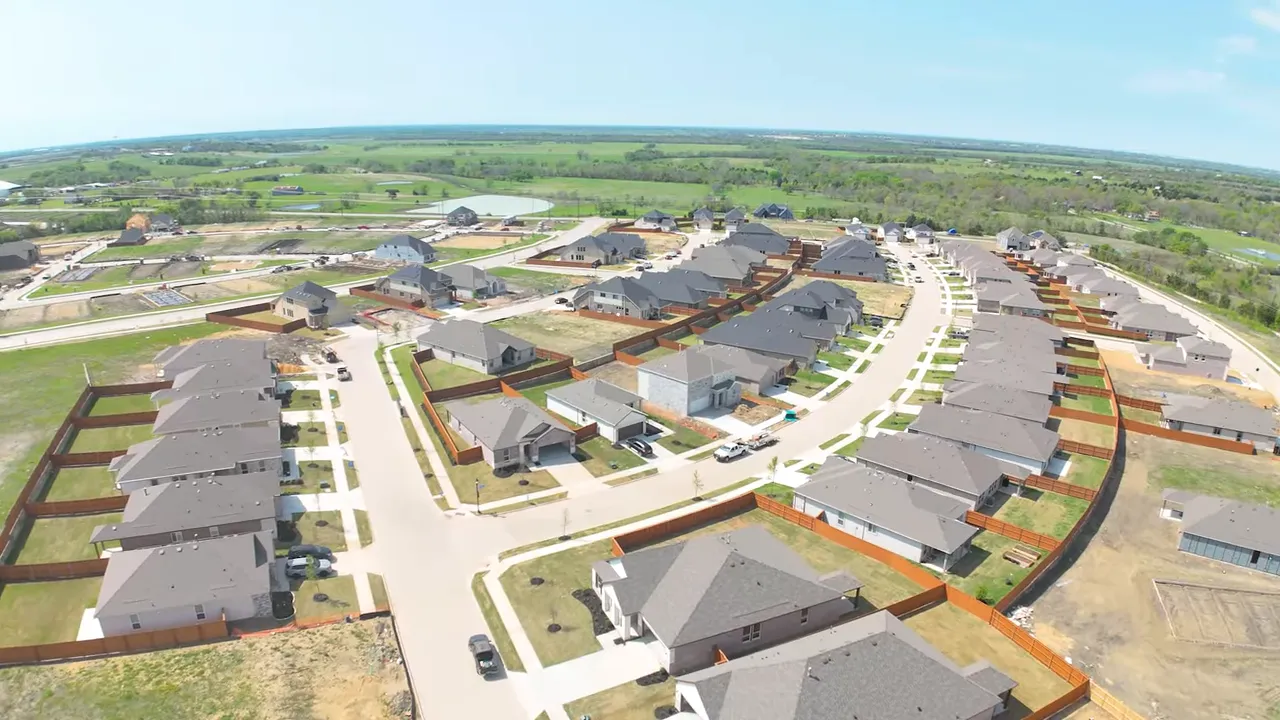 Master plan map of a residential development displayed on a monitor showing lakes, roads, lot layouts and phase boundaries.