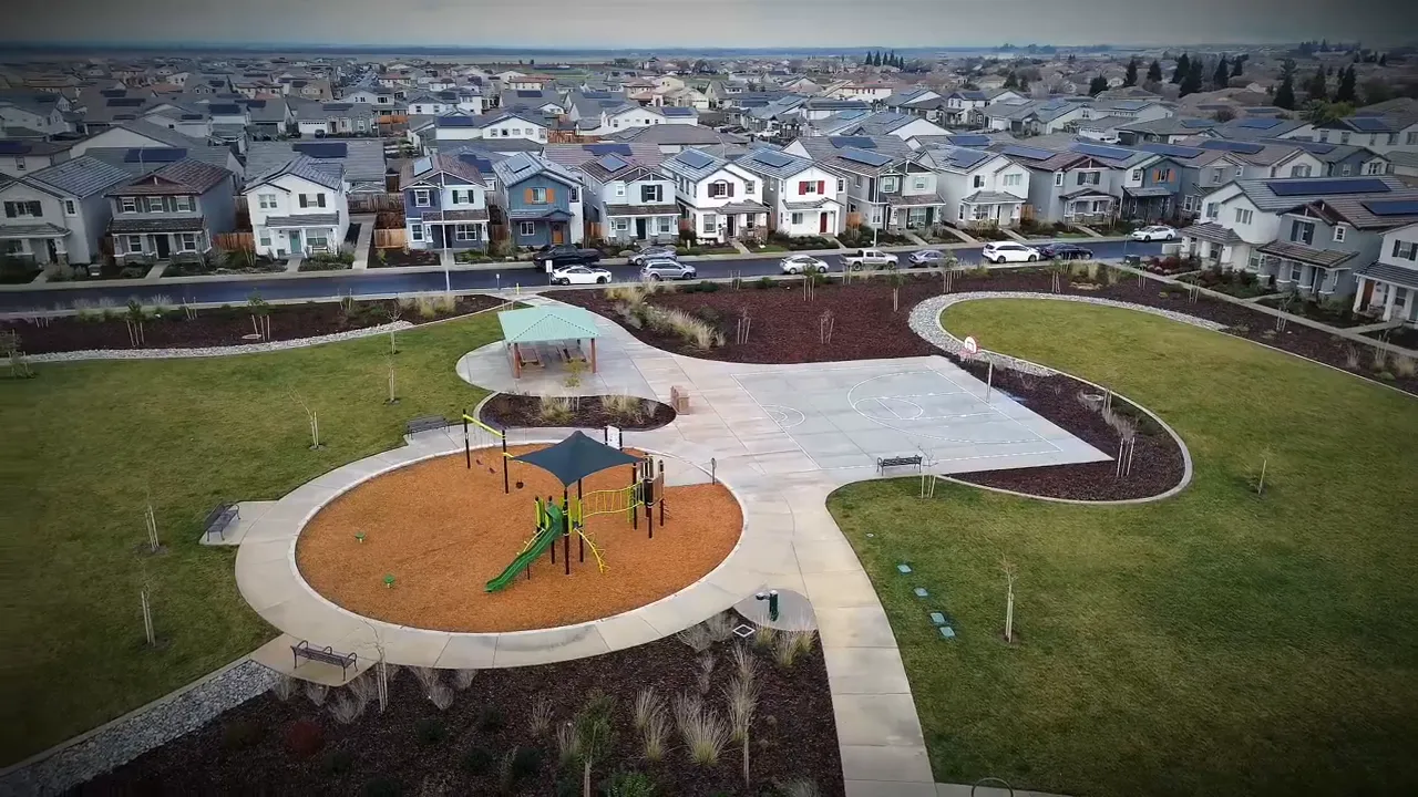 Aerial park and playground with basketball court and rows of newly built homes at The Ranch community