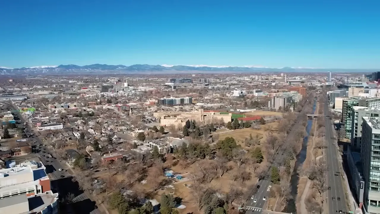 On-screen graphic stating Denver City Council approved up to $812 million for National Western Center hotel, housing, and equestrian uses