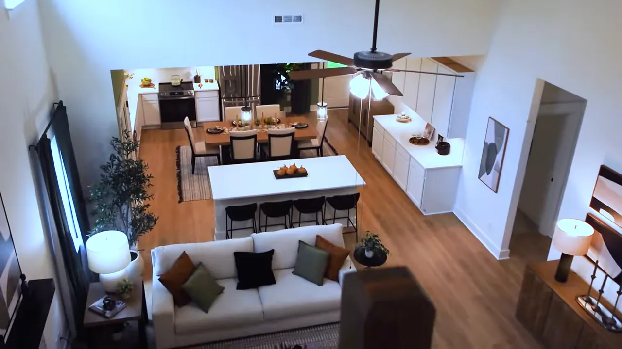 Loft railing overlooking open great room kitchen and dining area