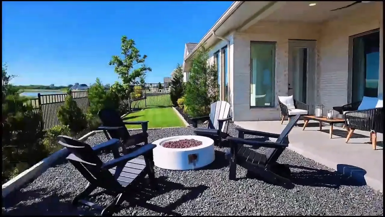 Covered backyard patio with outdoor chairs dining set and fenced greenbelt view
