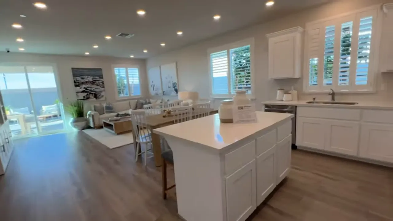 open hallway and kitchen with stainless steel refrigerator showing layout flow