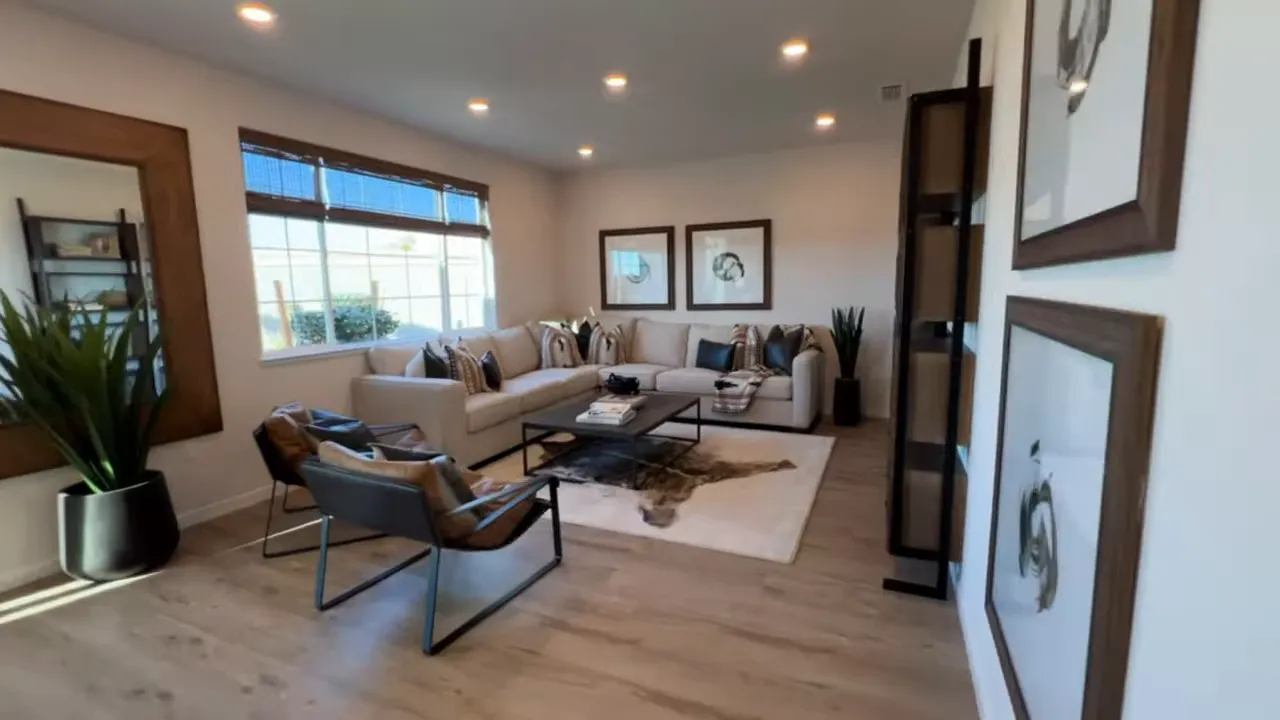 Staged home office flex room with desk, chairs, shelving and windows in a model home