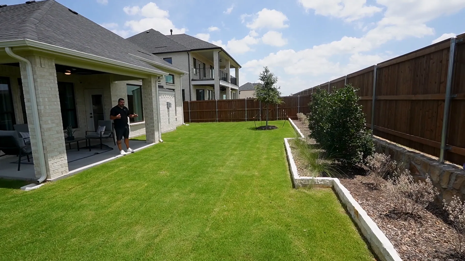 Covered patio with ceiling fan and spacious backyard