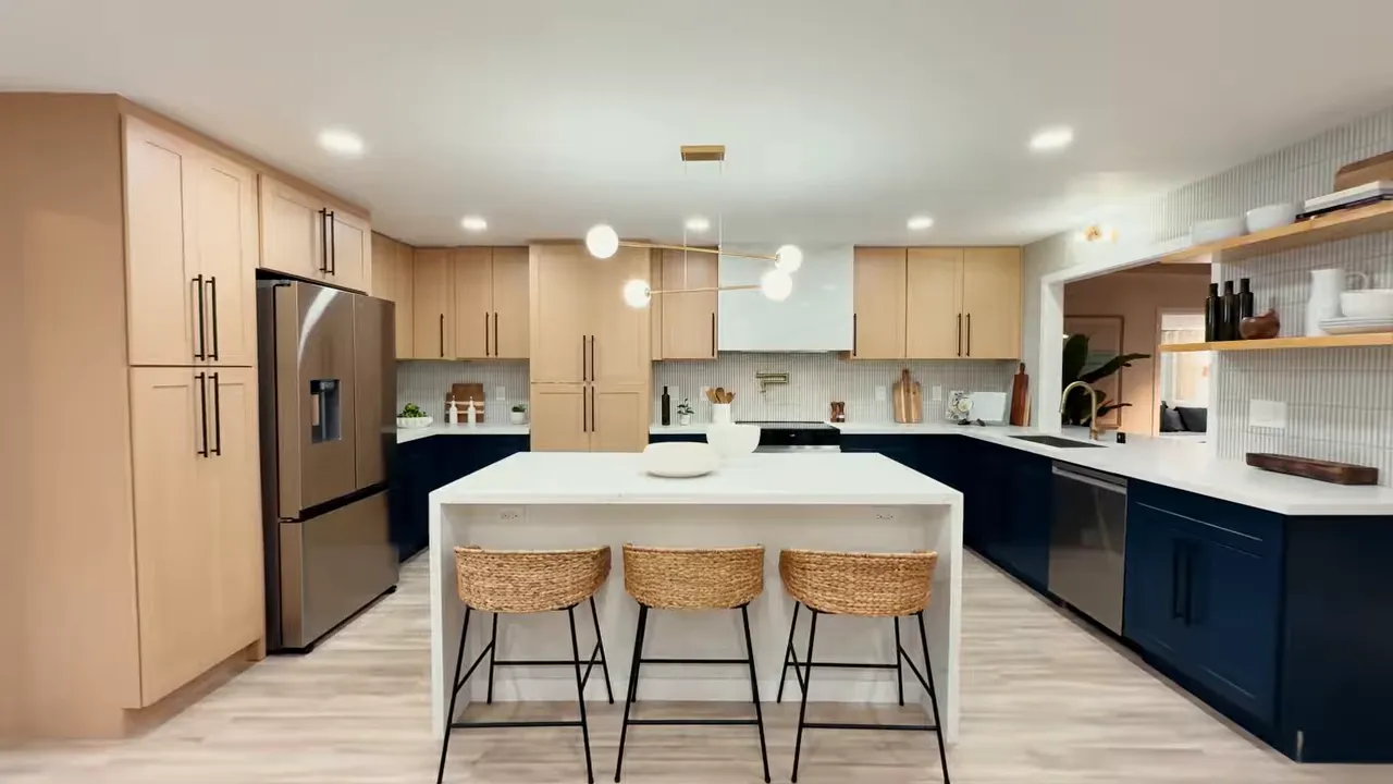 Clean wide view of renovated Kailua kitchen with light uppers and navy island cabinetry