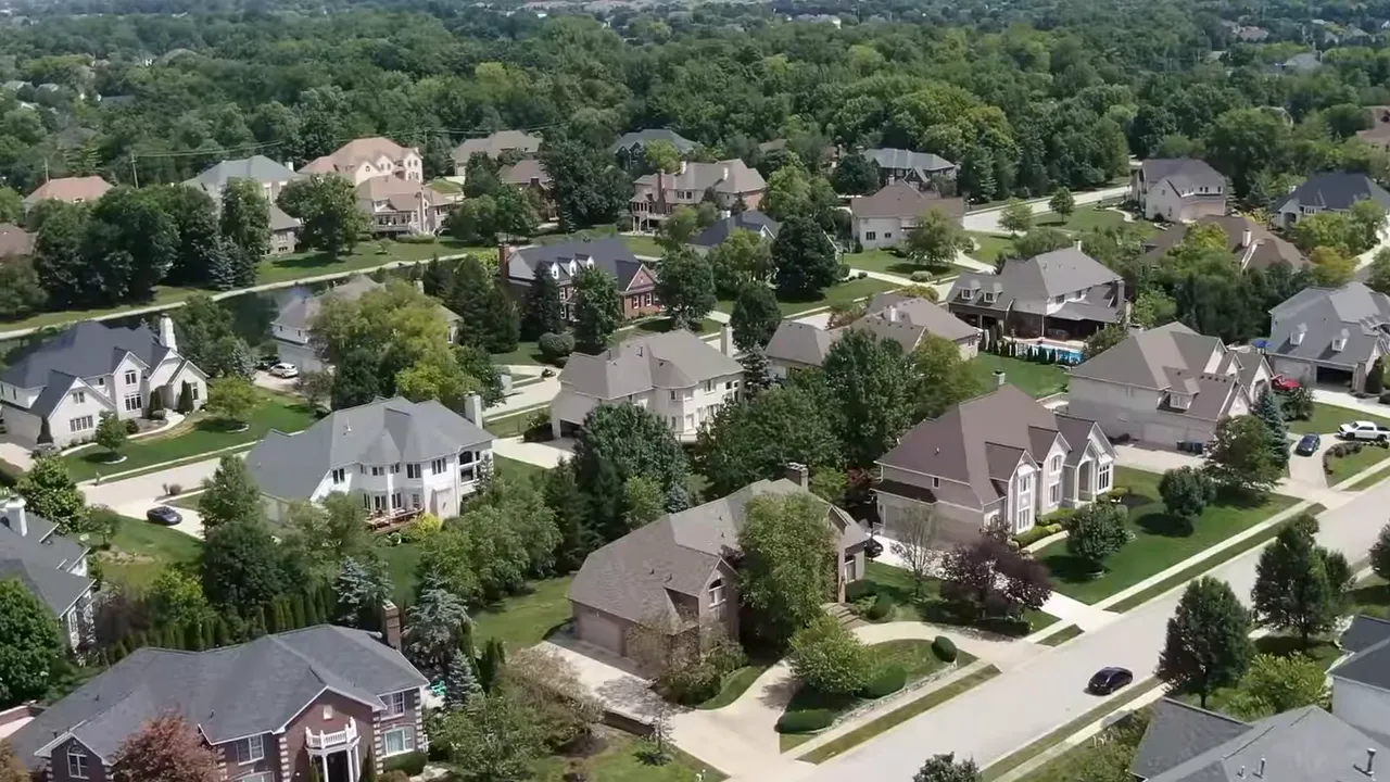 On-screen graphic showing 'Average days on market 29' and 'Price cut in Homes 0.33%' above illustrations of houses