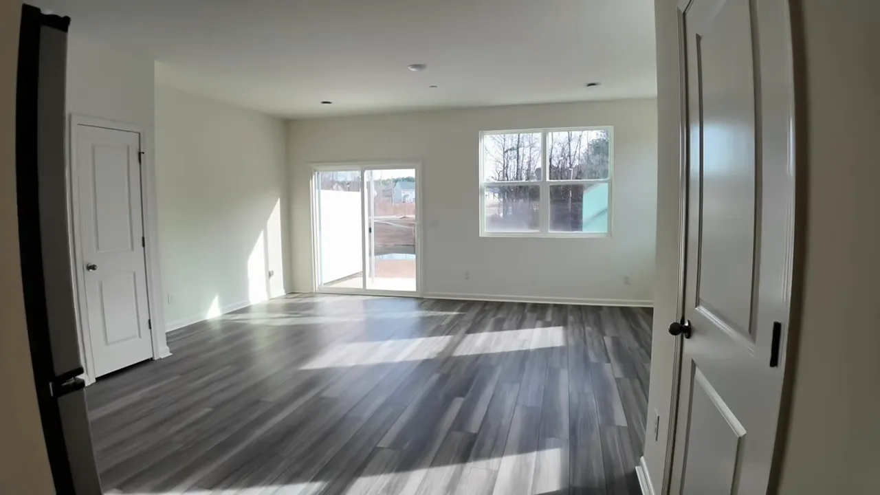 Top-down view of gray LVP plank flooring at the home entry, showing layout and door.