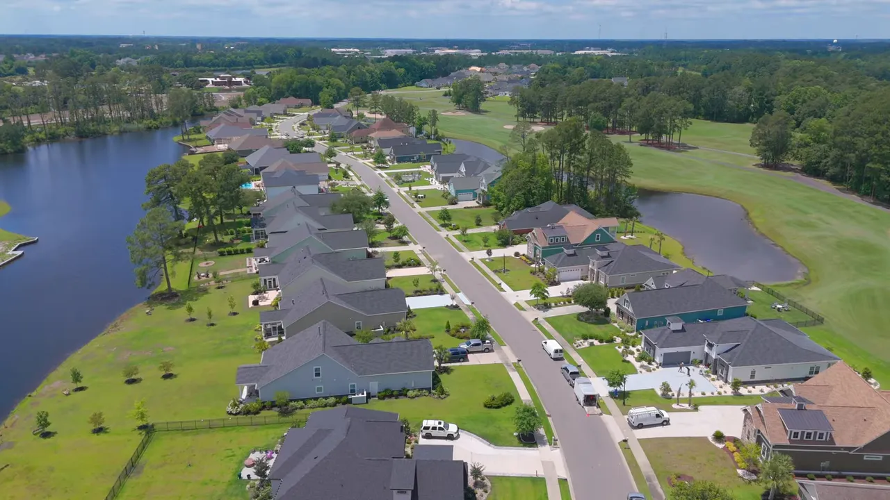 Google Maps satellite aerial of Wildwing Plantation showing golf course, water features, neighborhood layout and presenter inset
